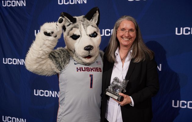 Ellyssa Eror, Student Health Services, poses with Jonathan the Husky after receiving the Unsung Hero Award